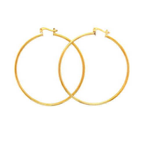 A pair of Big 5.4 cm Hoop Earrings in 14k gold-filled with a thickness of 2 mm and simple clasps. These statement pieces elegantly overlap against a plain white background.